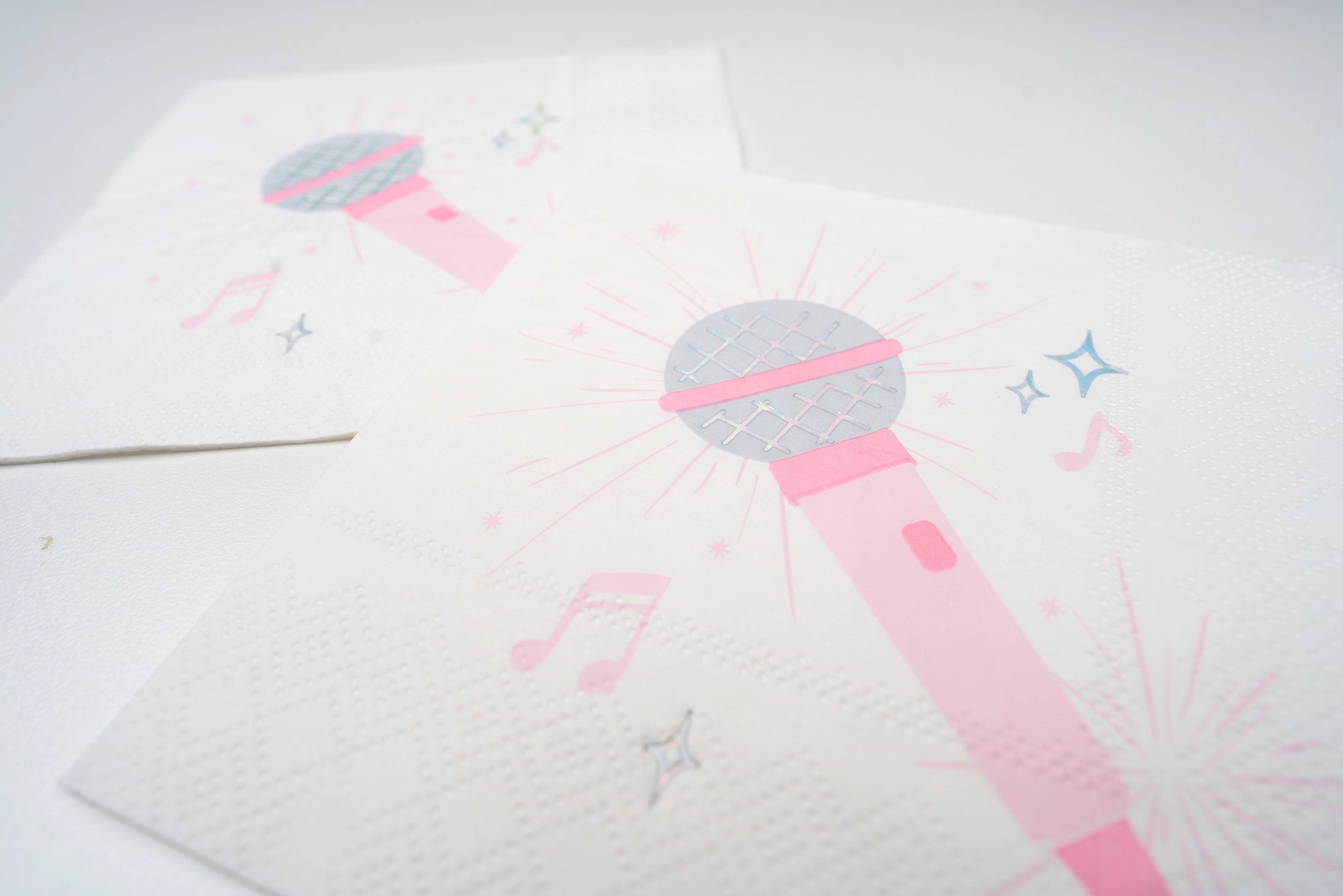 White paper napkin with pink microphone illustration