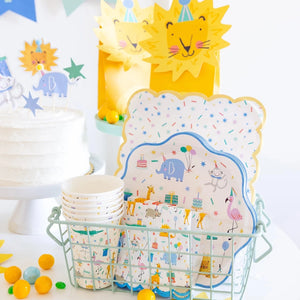 Children's party supplies, including plates, cups, and napkins with animal designs.