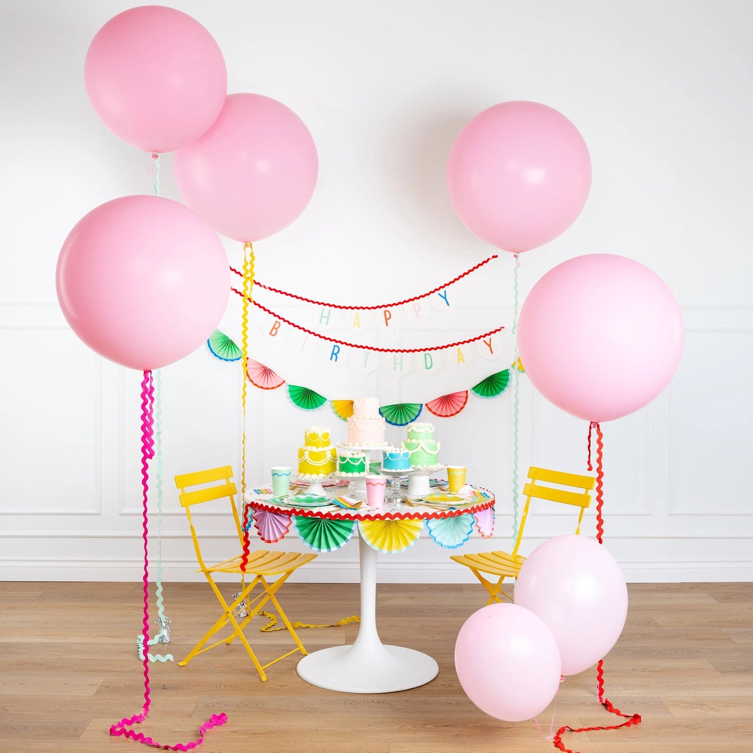 Birthday party setup with pink balloons, colorful birthday decorations