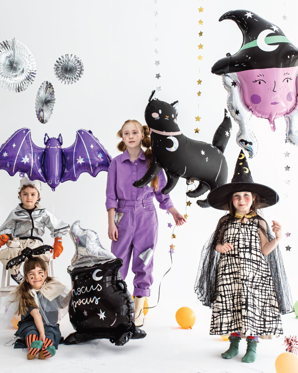 Children in Halloween costumes with themed Halloween balloons