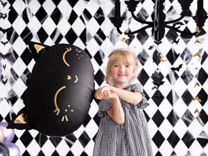 girl holding black cat balloon