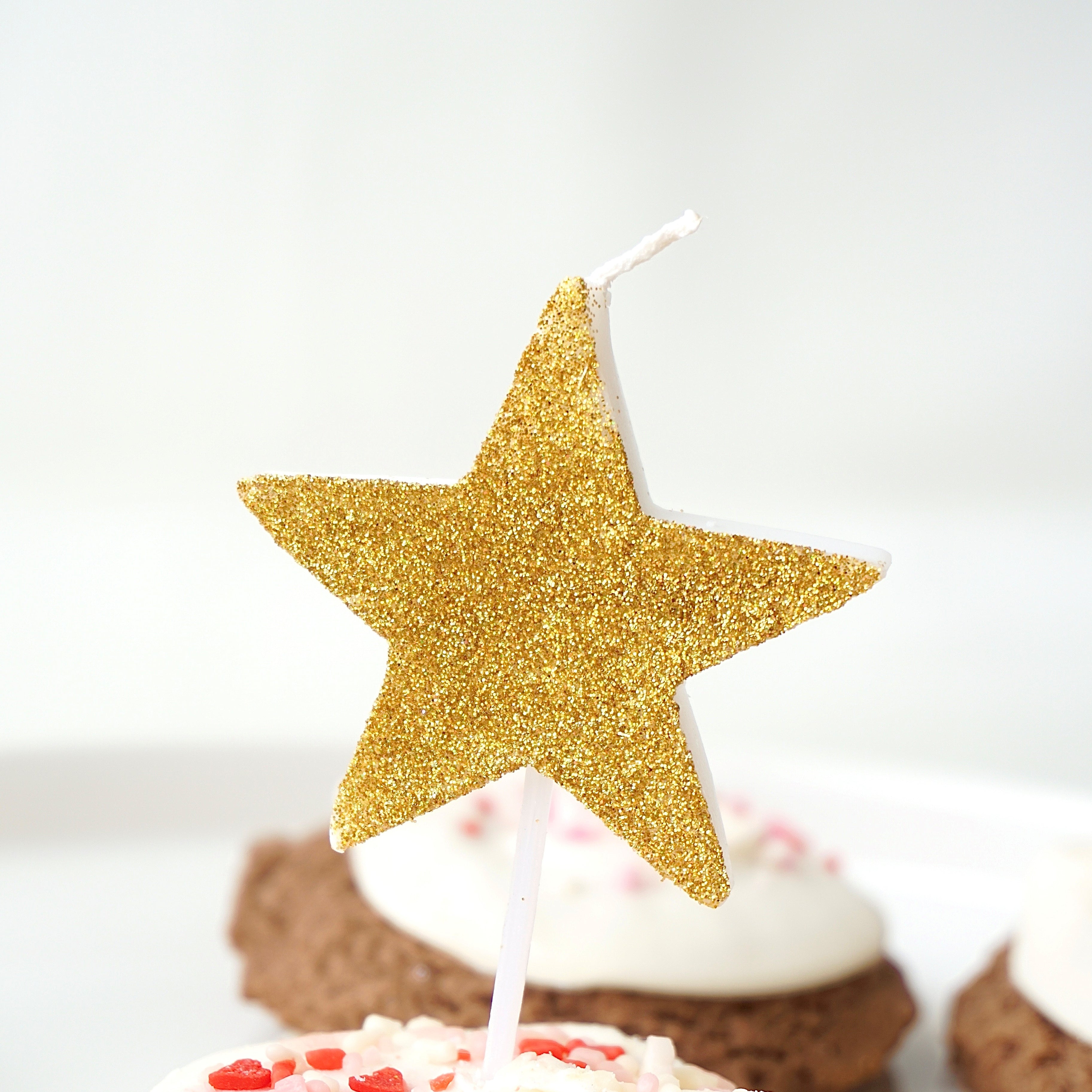 Gold glitter star candle on cupcake
