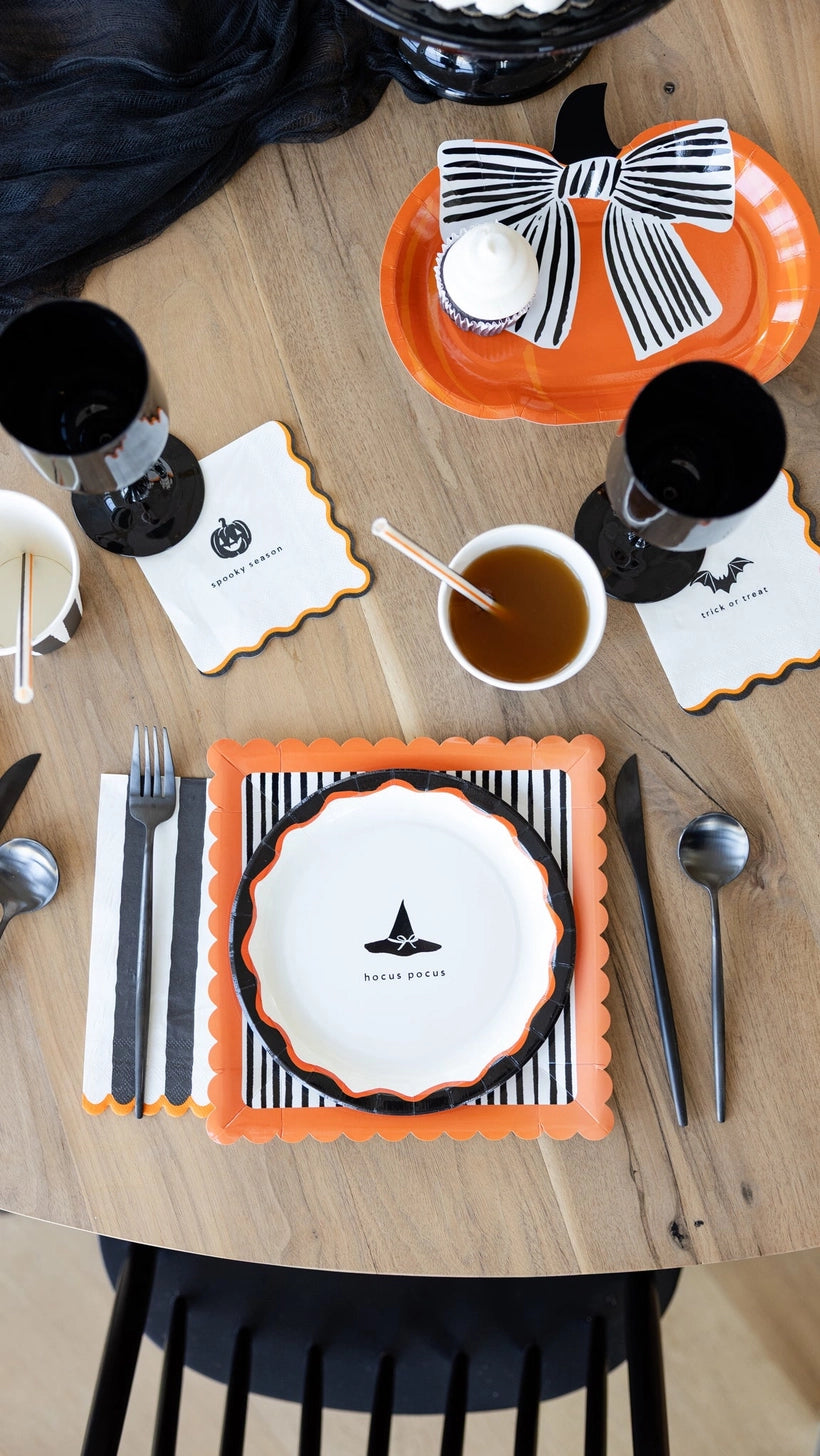 Halloween-themed table setting with black, orange, and cream decor