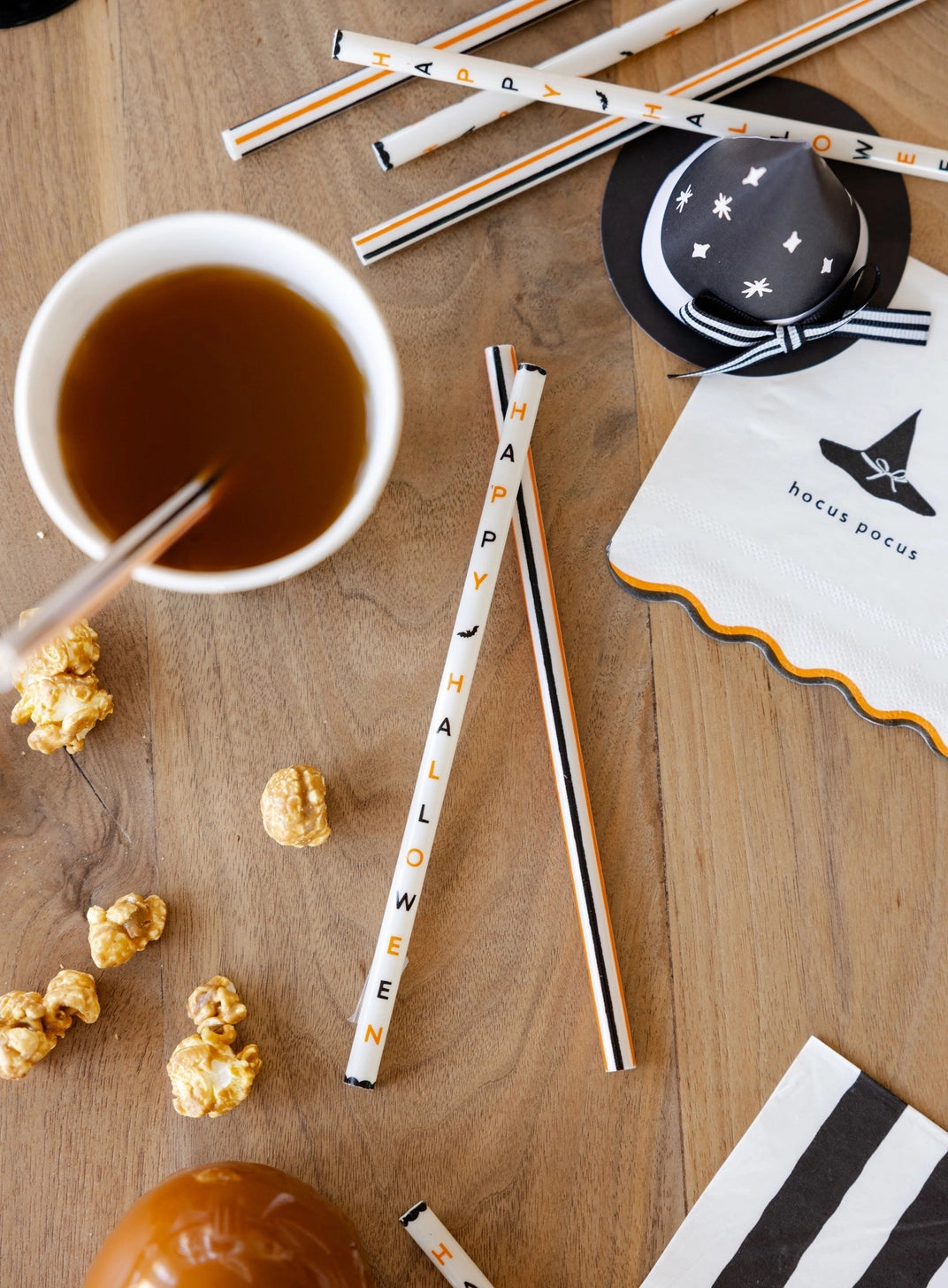 Halloween party straws styled with coordinating black and orange tableware