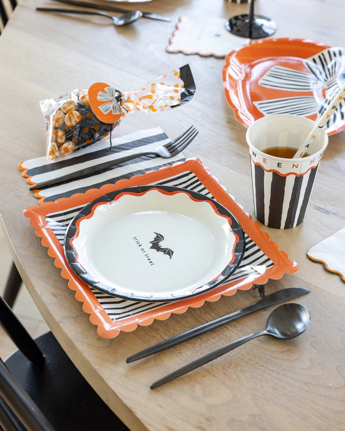 Halloween dinner plates styled with black, cream, and orange tableware