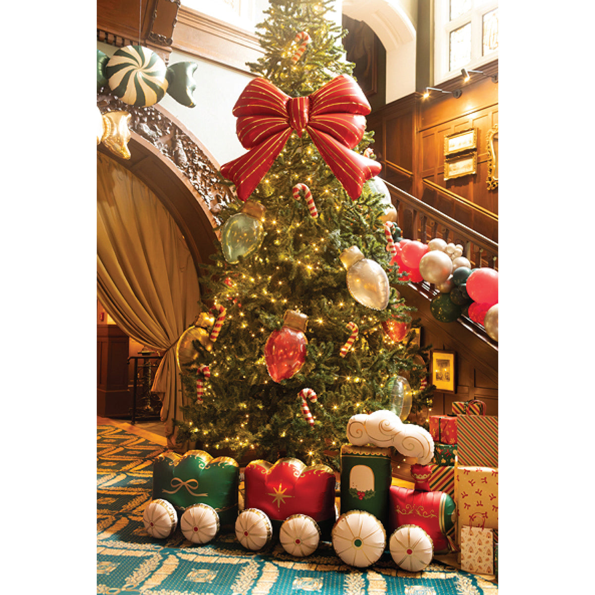 Large red and gold striped bow-shaped foil balloon for Christmas parties and holiday decorations.