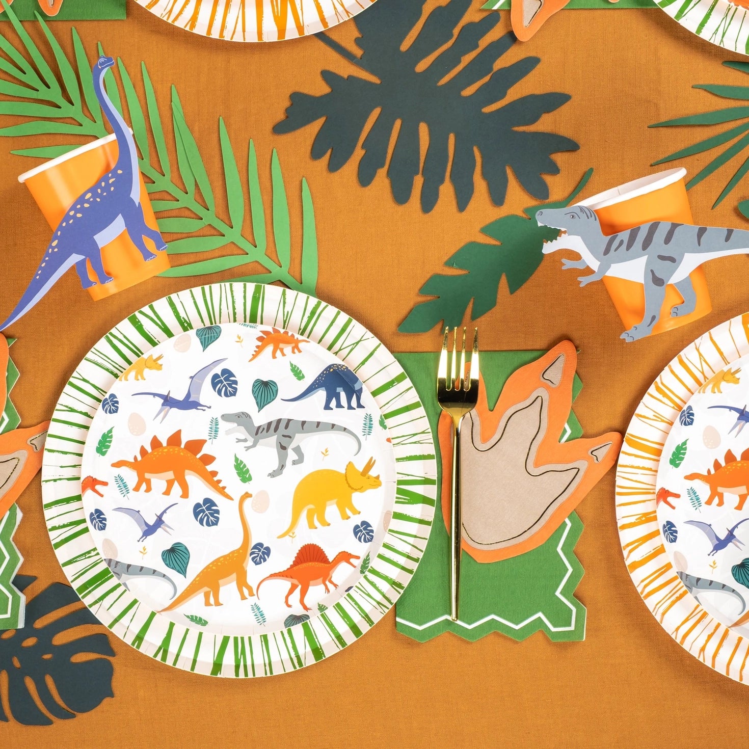 Dinosaur-themed paper dessert plate with colorful illustrations