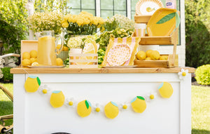 Lemon-themed felt banner displayed outdoors on a party backdrop