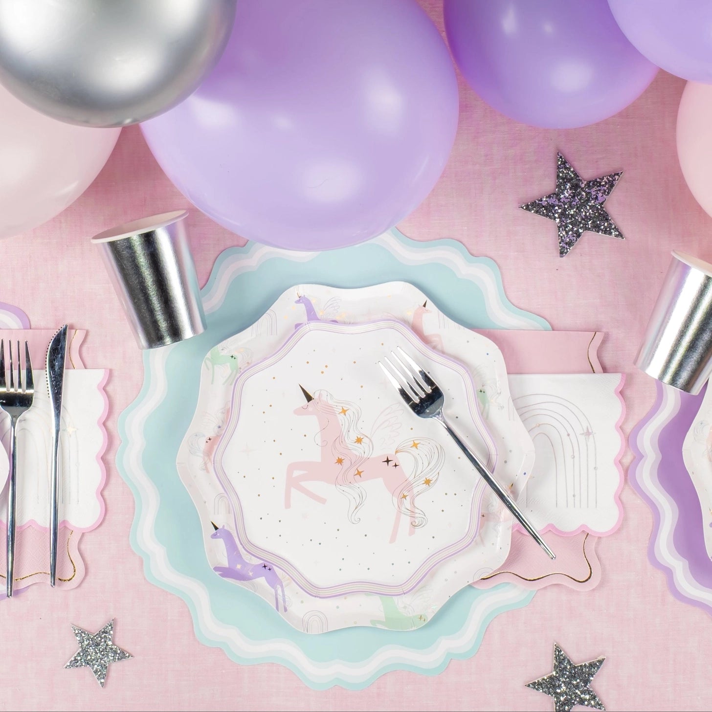 Party table setting with unicorn-themed plates, napkins and placemats