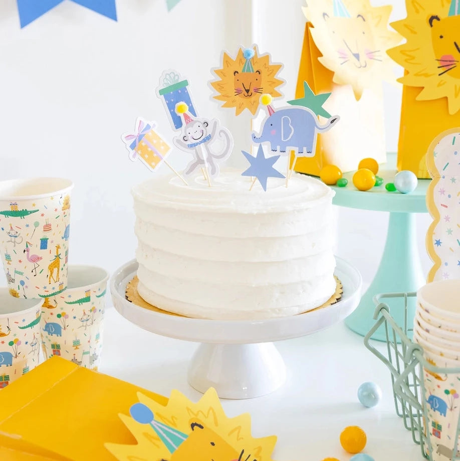 Colorful animal party picks displayed on frosted birthday cake