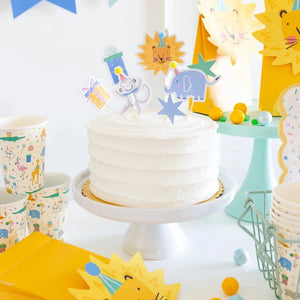 Colorful animal party picks displayed on frosted birthday cake