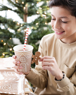 Child holding a Gingerbread house paper cup with gingerbread man handle