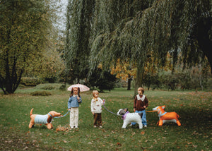 Children walking air-filled dog balloons