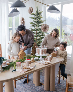 Family having a gingerbread house decorating party with gingerbread party decorations