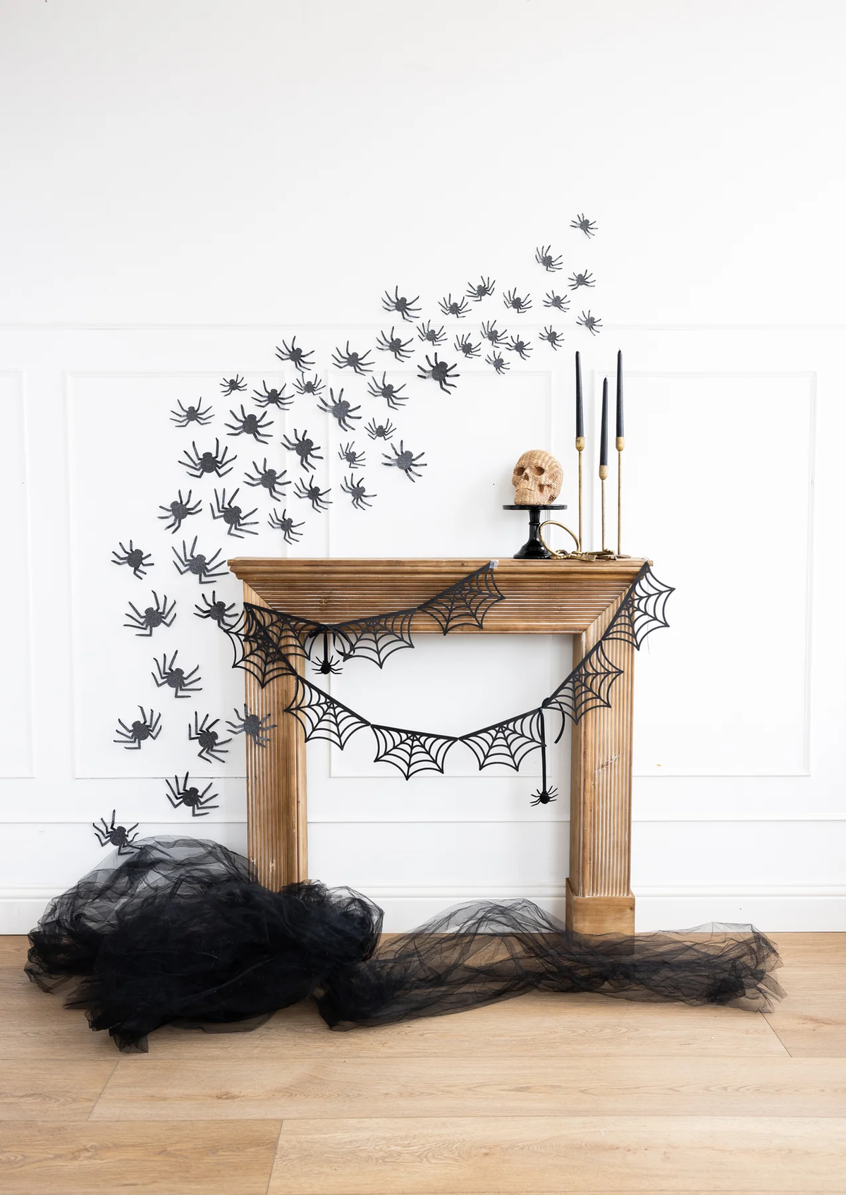 Black Glitter Spiders Halloween Wall Decorations, including spider webs and black tulle on a fireplace.