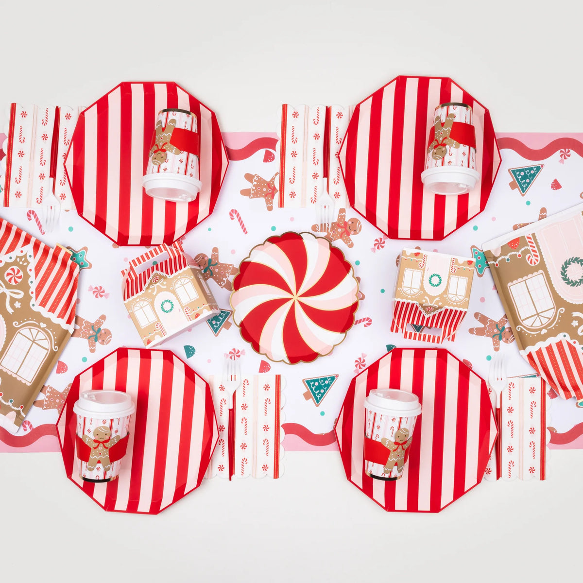 Set of gingerbread house Christmas-themed paper plates, cups, and napkins with red and white striped design