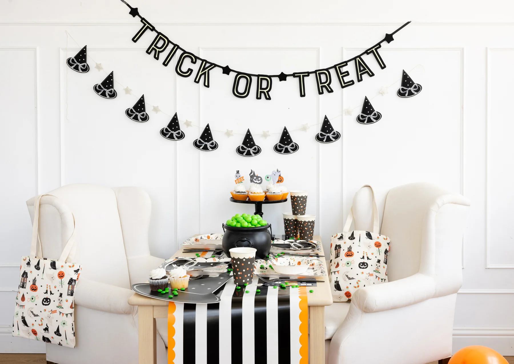 Halloween-themed table setting with 'Trick or Treat' banner and decorative items.