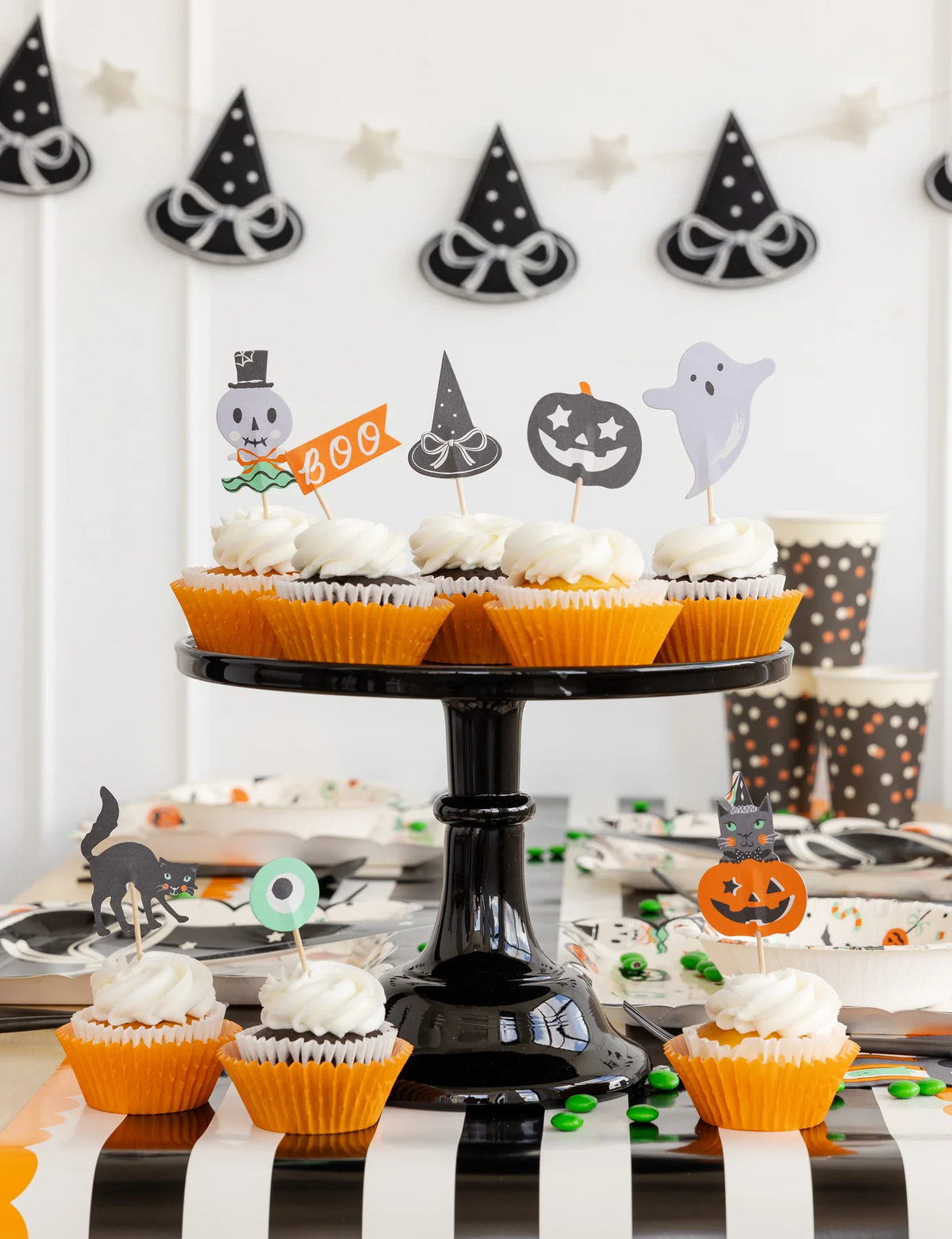Halloween cupcakes on a black cake stand with Halloween cupcake toppers.