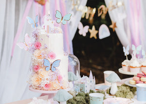 Tiered Birthday Cake with flowers, a Unicorn Candle, and Butterfly Cake Toppers